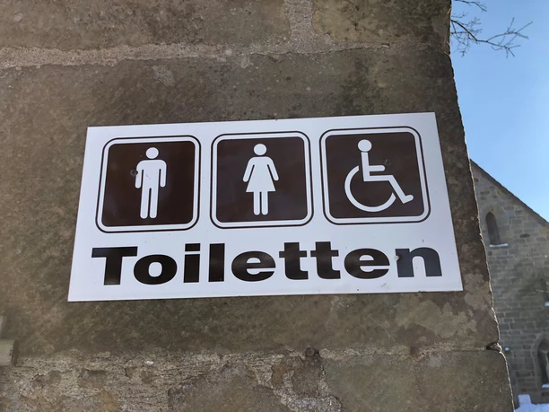 öfftl. WC Kloster Loccum Toilettenschild am Kloster Loccum mit Symbolen für Herren, Damen und barrierefreien Zugang.