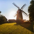 Lübbecke Windmühle Eilhausen Lübbecke Windmühle Eilhausen bei Sonnenuntergang, umgeben von grüner Wiese und Bäumen.