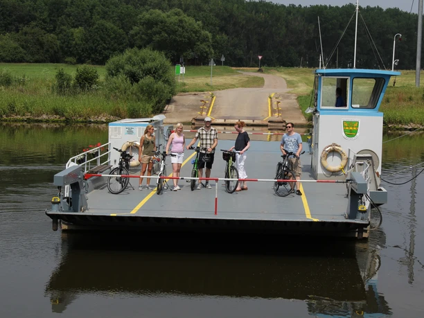 Færgen Schweringen krydser Weser med fem personer og cykler på en solrig, stille overfart.