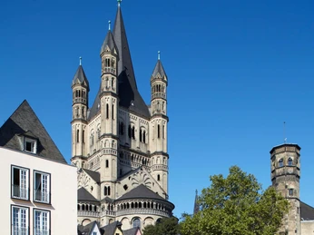 Cologne's old town with Groß St. Martin Ansicht der romanischen Kirche Groß St. Martin in Köln, umgeben von farbigen Altstadthäusern.View of the Romanesque church Groß St. Martin in Cologne, surrounded by colorful old town houses.