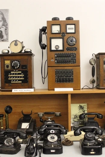 Verschiedene historische Telefone, Schaltboards und Fotos sind in einer Ausstellung zur Telekommunikation zu sehen.