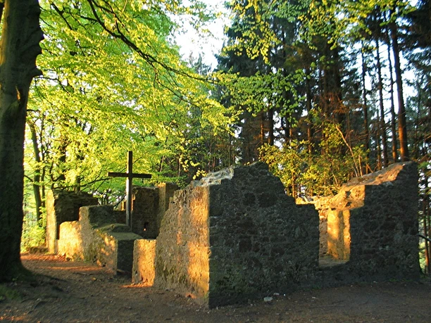 Hünenkapelle auf dem Tönsberg in Oerlinghausen Ruinen der Hünenkapelle auf Tönsberg in Oerlinghausen, umgeben von dichtem Wald und Sonnenlicht.