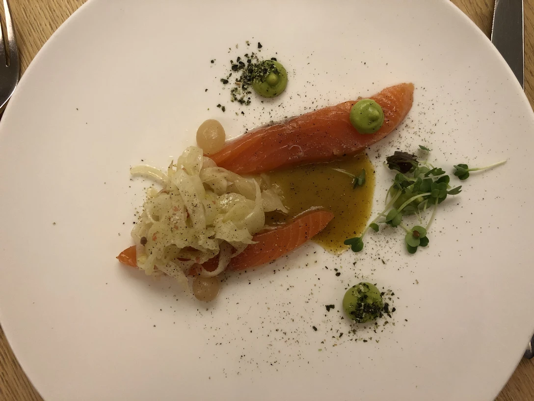 Fischgericht Lachsfilet mit Zwiebelchutney und Kräutergarnitur, dekorativ angerichtet auf weißem Teller.Salmon fillet with onion chutney and herb garnish, decoratively served on a white plate.Laksefilet med løgchutney og urtegarniture, dekorativt serveret på en hvid tallerken.Zalmfilet met uienchutney en kruidengarnituur, decoratief geserveerd op een wit bord.