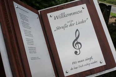 Marklohe Straße der Lieder Willkommensschild der "Straße der Lieder" mit Notenschlüssel und Gedicht, inspiriert zum Mitsingen.