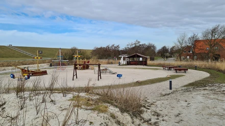 Trockenstrand Upleward Spielplatz Zu sehen sind mehrere Spielgeräte auf dem Trockenstrand in Upleward. Im Hintergrund der Deich,