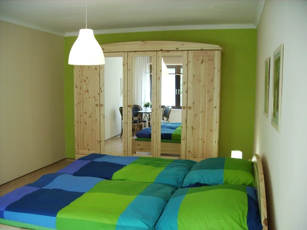 Schlafzimmer Ferienwohnung Lademann Für einen geruhsamen Schlaf sorgen ein massives Doppelbett der Größe 1,80 x 2,00 m mit verstellbarem Lattenrost und orthopädischen 5-Zonen- Hydrocell-BioVita-Matratzen. Im großen Kleiderschrank läßt sich problemlos Ihr Reisegepäck verstauen. Bettwäsche stellen wir Ihnen gern gegen ein kleines Entgelt zur Verfügung. Eine kleine Sitzgruppe bietet die Möglichkeit sich zurückzuziehen und z.B. zu lesen.