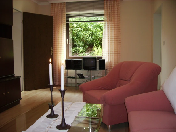 Wohnzimmer Ferienwohnung Lademann Das in hellen Farben gehaltene Wohnzimmer lädt zum Kuscheln an Abenden oder auch einem verregneten Ferientag ein. Neben einem Fernseher mit SAT-Anlage ist ein DVD-Player sowie eine Stereo-Anlage mit CD-Player vorhanden. Unsere " Herbstkollektion" mit diversen Büchern und Spielen vertreibt an Regentagen sicherlich zusätzlich ein wenig die Zeit. Auf der Schlafcouch mit einer Liegefläche von 1,50 x 1,80 m finden weitere Gäste sicherlich einen erholsamen Schlaf.