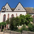 Eine gotische Kirchenfassade mit dreieckigen Giebeln und Spitzbogenfenstern unter strahlend blauem Himmel.