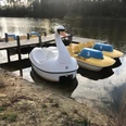 Bootsanleger am Obersee Tretboote in Form eines Schwans und Enten schwimmen an einem Holzsteg auf einem ruhigen See.