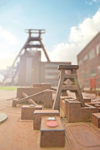 RevierRoute Probierstück.jpg <p>Miniaturmodell der Zeche Zollverein mit Förderturm und historischen Backsteingebäuden im Hintergrund.</p>