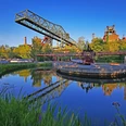 RevierRoute Stahlküche.jpg <p>Industrieanlage im Landschaftspark Duisburg-Nord mit Wasserbecken, blauer Himmel und grüner Natur.</p>