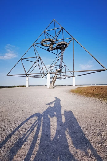 RevierRoute Grubenfahrt.jpg <p>Ein dreieckiger Stahl-Tetraeder mit einer Treppe im Kontrast zum blauen Himmel.</p>