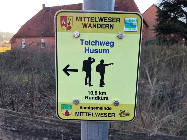 Wandelwegwijzer in Husum, die de 10,8 km lange "Teichweg" rondwandeling door de regio Midden-Weser aangeeft.