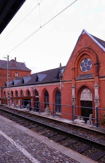 Historisches Bahnhofsgebäude in Detmold mit rotem Backstein und charakteristischer Rosettenfenster.