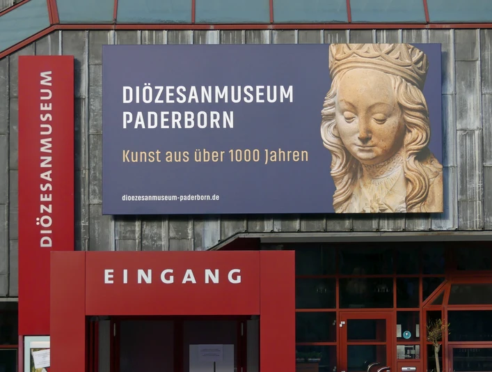 Eingang zum Diözesanmuseum Eingang zum Diözesanmuseum Paderborn mit großem Plakat für Kunst über 1000 Jahre im Hintergrund.