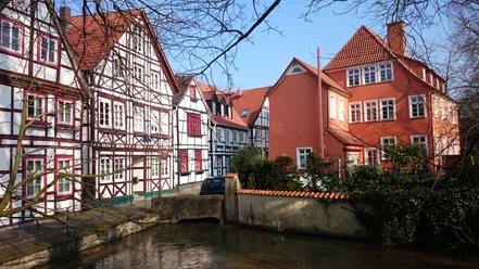 Fachwerkhäuser in bunten Farben, entlang eines kleinen Flusses, strahlen Ruhe und Tradition aus.
