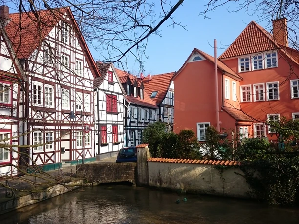 Fachwerkhäuser in bunten Farben, entlang eines kleinen Flusses, strahlen Ruhe und Tradition aus.
