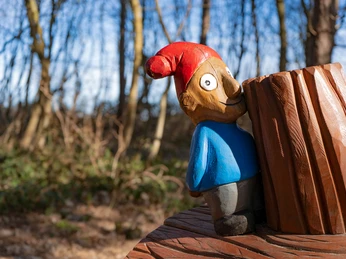 Puk auf Baumstamm Kleiner Puk versteckt sich auf Baumstamm