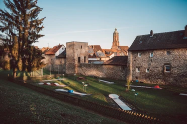 Minigolfplatz am Bäckerwall Minigolfanlage im Grünen vor historischer Stadtmauer von Einbeck mit Blick auf alte Häuser und Kirchturm
