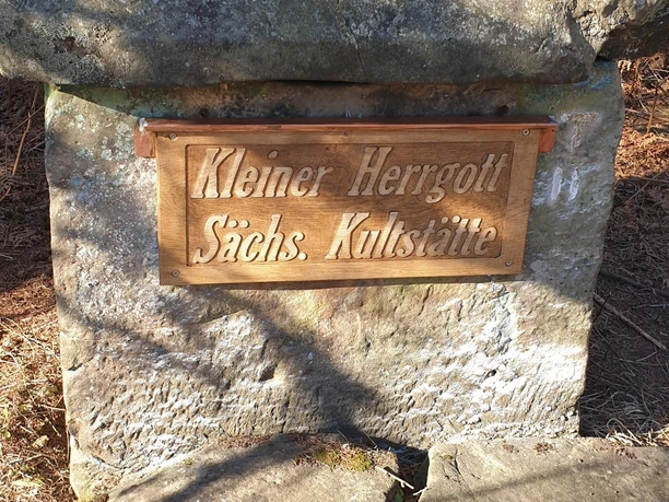 Der Kleine Herrgott hat ein neues Schild erhalten. Steinmonument im Wald, mit neuem Schild "Kleiner Herrgott, Sächs. Kultstätte" versehen.