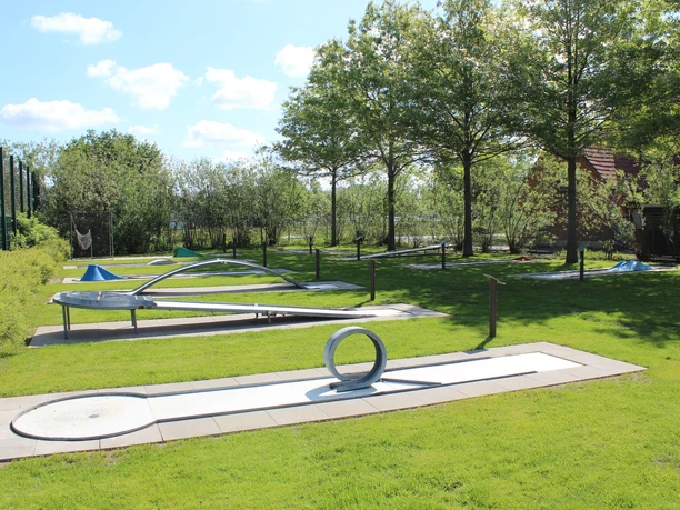 Minigolfanlage im Parkteil Nord Moderner Abenteuergolfplatz auf grüner Wiese unter Bäumen, mit verschiedenen kreativen Bahnen.
