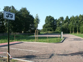 Wohnmobilstellplatz Rehburg bietet ebene, asphaltierte Plätze, umgeben von grünen Bäumen und Wiesen.