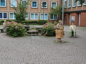 Rathaus Petershagen mit Lechner-Figuren Auf einem gepflasterten Platz stehen bunte Lechner-Figuren vor dem historischen Rathausgebäude.