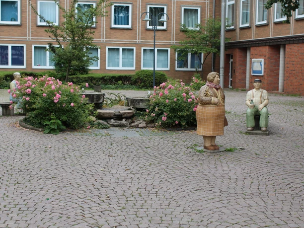 Rathaus Petershagen mit Lechner-Figuren Auf einem gepflasterten Platz stehen bunte Lechner-Figuren vor dem historischen Rathausgebäude.