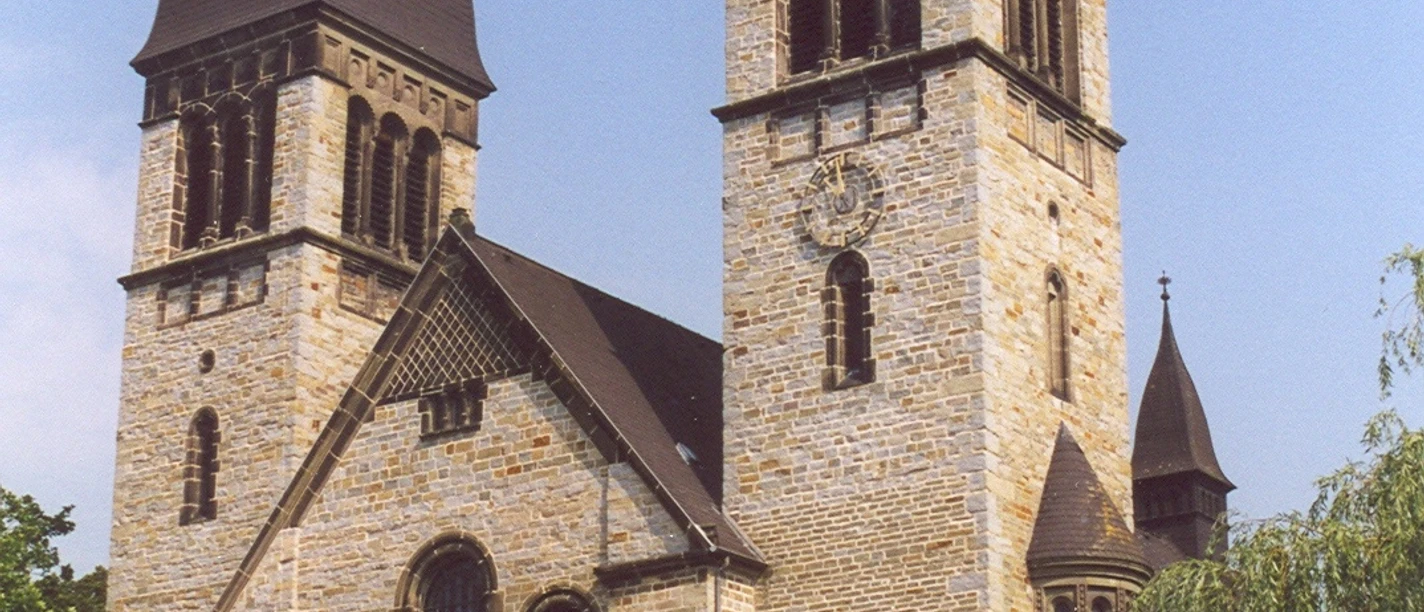 Eine historische Kirche mit zwei markanten Glockentürmen und einem reich verzierten Eingangsportal.