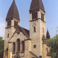 Kirche St. Clemens in Rheda Eine historische Kirche mit zwei markanten Glockentürmen und einem reich verzierten Eingangsportal.