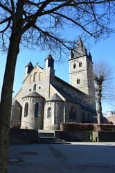 Kirche St. Nikolaus St. Nikolaus Kirche in Wipperfürth bei blauem Himmel, im Vordergrund ein Baum mit kahlen Ästen.