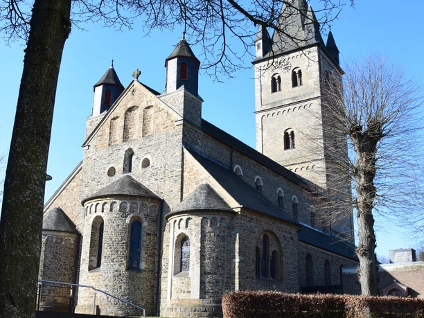 Kirche St. Nikolaus St. Nikolaus Kirche in Wipperfürth bei blauem Himmel, im Vordergrund ein Baum mit kahlen Ästen.
