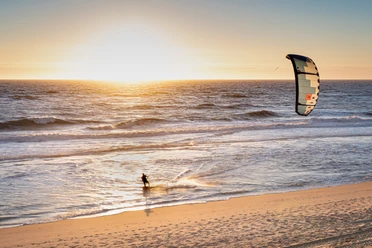 Kitesurfer im Sonnenuntergang Kitesurfer im Sonnenuntergang am Strand von Wenningstetd