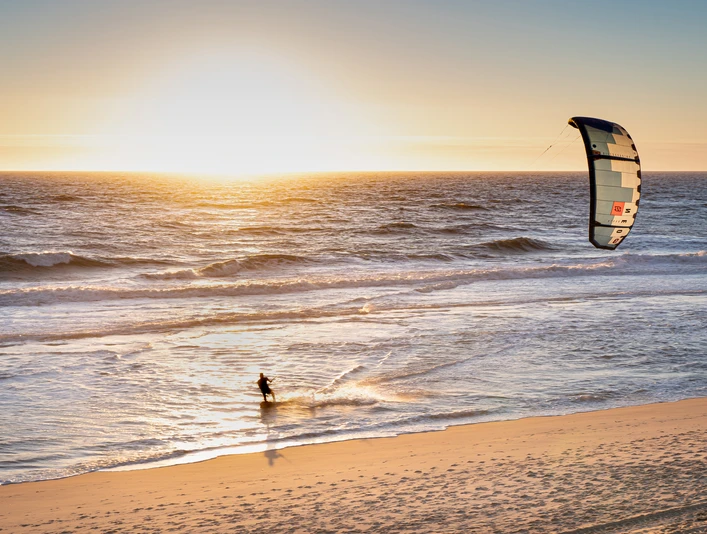 Kitesurfer im Sonnenuntergang Kitesurfer im Sonnenuntergang am Strand von Wenningstetd