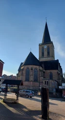 St.-Andreas-Kirche in Emsbüren Sandstein-Kirche mit hohem Turm, spitzem Dach und großen Maßwerkfenstern unter blauem Himmel