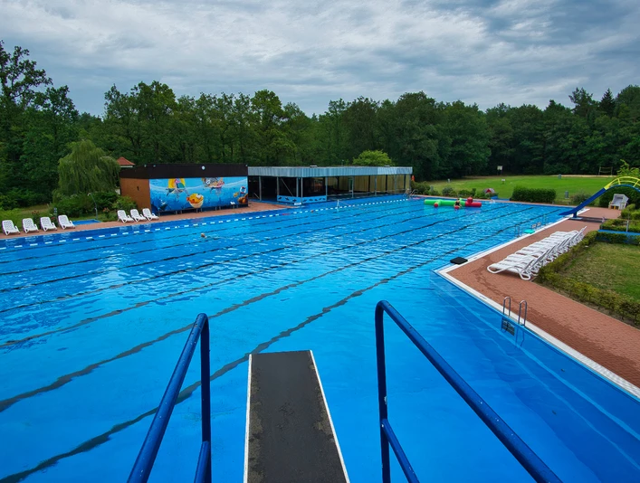 Schwimmerbecken Ein großzügiges, blaues Schwimmerbecken umgeben von Bäumen lädt zum Entspannen und Schwimmen ein.