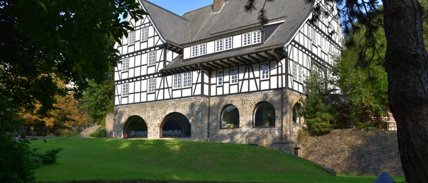 2018_Hungenbach_Kuerten__155_.jfif Fachwerkhaus im Grünen, mit großem Rasen davor und einem kleinen Teich im Vordergrund.