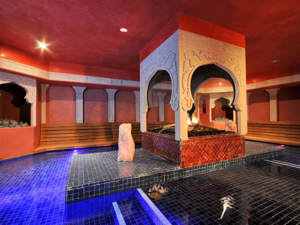 Neubau der Mediterana Wellnessanlage Ein opulent gestaltetes, orientalisches Spa mit einem zentralen, überdachten Ruhebereich und blauem Mosaikboden.
