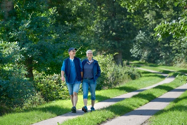 Franziskusweg Windbergen Zwei Menschen beim Spaziergang auf grünem Weg