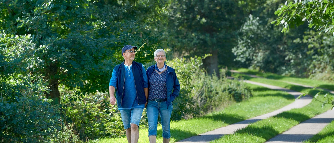 Franziskusweg Windbergen Zwei Menschen beim Spaziergang auf grünem Weg
