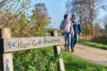 Klaus Groth Wanderweg Holzschild Klaus-Groth-Wanderweg mit Gehenden