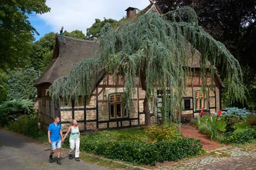 Luftkurort Burg und der Burger Wald Fachwerkhaus im Wald mit zwei wandernden Personen