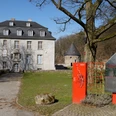 Schloss Hardenberg Das Bild zeigt das historische Haus Kemnade mit Infotafel im Vordergrund an einem sonnigen Tag.