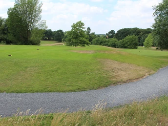 Syke Golfplatz Grüner, weitläufiger Golfplatz in Syke mit gepflegten Rasenflächen und Bäumen am Horizont.