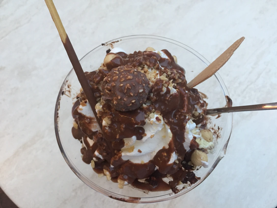 Eisbecher Ein köstlicher Eisbecher mit Schokoladenstücken, Sahne, zartem Krokant und einer Ferrero Rocher-Praline.