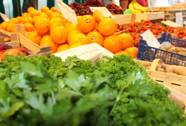 Wochenmarkt Stolzenau Frische Orangen und saftige Erdbeeren auf dem Wochenmarkt in Stolzenau; im Vordergrund frische Kräuter.