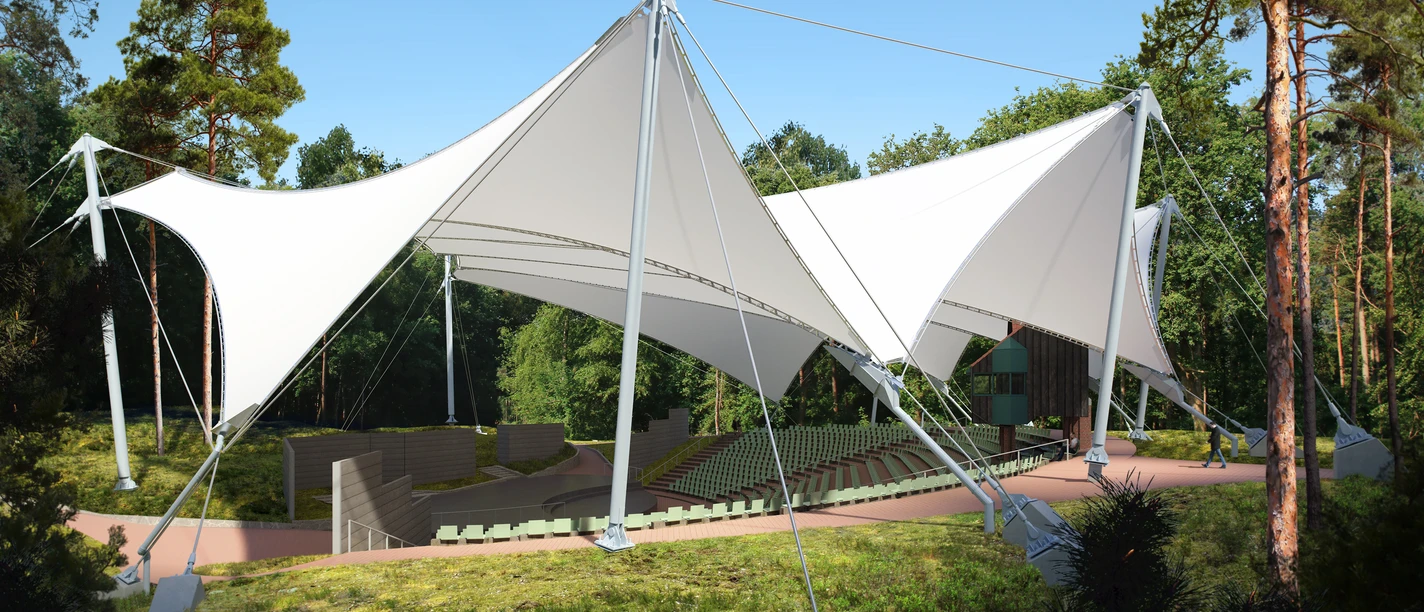 Emsländische Freilichtbühne Meppen Freilichtbühne mit moderner, weißer Membrandachkonstruktion, umgeben von Bäumen im Sonnenlicht.