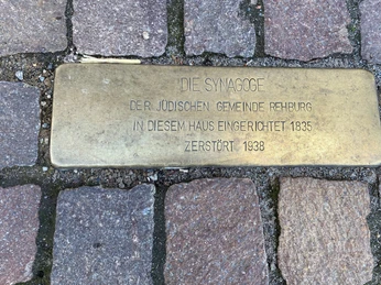 Gedenktafel aus Messing auf Kopfsteinpflaster erinnert an die 1835 errichtete Synagoge in Rehburg.
