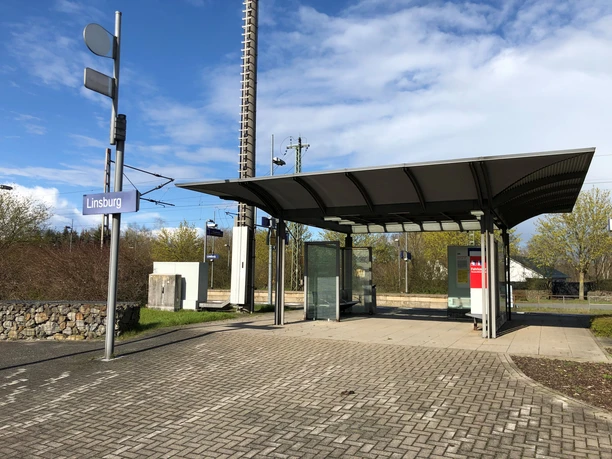 Bahnhof Linsburg Moderner Bahnhof in Linsburg mit überdachtem Wartebereich und Visualisierungsdisplay.