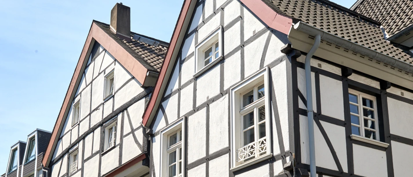 Altstadt, Mülheim an der Ruhr Fachwerkhaus mit grün-blauen Fensterläden in einer Altstadt an einem Sommertag.